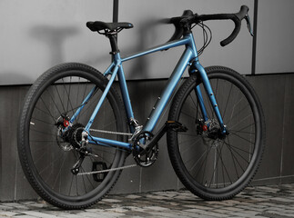 Fototapeta na wymiar Gravel bicycle. Shiny blue bike for offrad cycling on grey background. Close up.