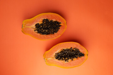 two papayas with orange background