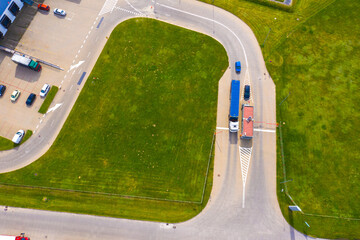 Aerial view of warehouse with trucks driving to the logistic center. Industrial background. Logistics from above.