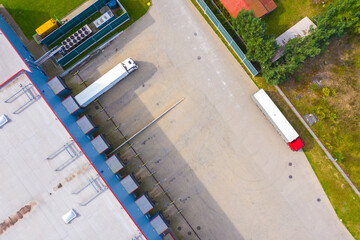 Aerial drone view of group of large modern industrial warehouse or factory buildings in suburban city area.Logistic transportation cargo terminal