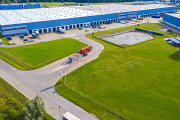Naklejka premium Aerial Shot of Industrial Loading Area where Many Trucks Are Unloading Merchandise.