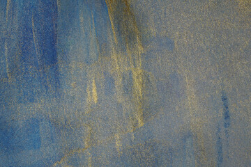 Golden grunge watercolor background on paper stains of shiny paint with blue.
