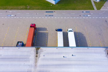Aerial top view of the large logistics park with warehouse, loading hub with many semi-trailers...