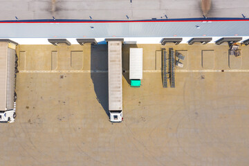 Aerial top view of the large logistics park with warehouse, loading hub with many semi-trailers trucks.