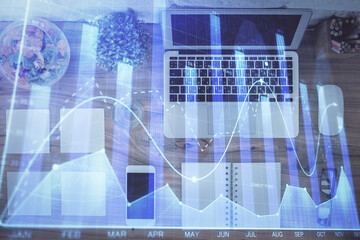 Stock market graph and top view computer on the table background. Multi exposure. Concept of financial education.