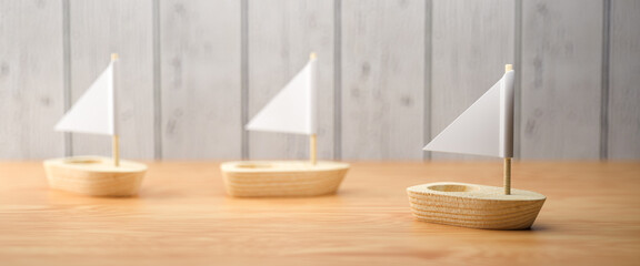 three little wooden boats in a row on wooden background