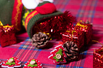 christmas decoration on red background: toy gifts and pine cones and sock with Santa Claus, tinsel and Christmas trees. 2021 new year theme. template for postcards.