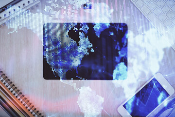 Double exposure of forex graph hologram over desktop with phone. Top view. Mobile trade platform concept.