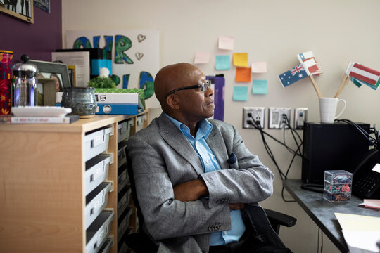 Teacher Sitting In Office Looking Away