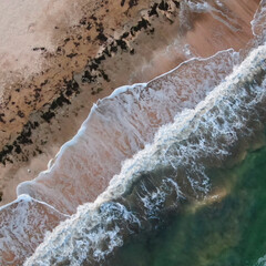 Drone view of the green sea and yellow sand on the beach. the sea during a storm, sea waves...
