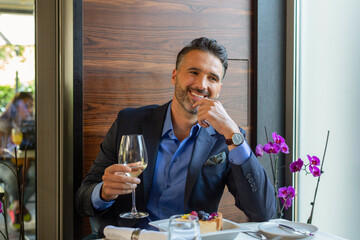 Handsome man drinking white wine in the restaurant