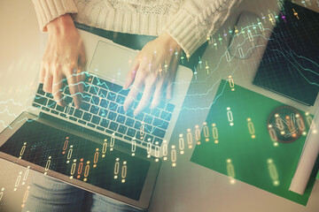 Double exposure of woman hands working on computer and forex chart hologram drawing. Top View. Financial analysis concept.