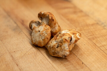 White chanterelle mushrooms on a wooden cutting board