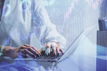 Double exposure of woman hands typing on computer and forex chart hologram drawing. Stock market invest concept.