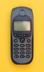 Obsolete mobile phone on a yellow background