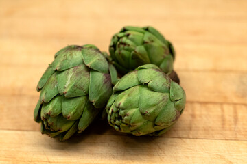 Obraz premium baby artichokes on a wooden background cutting board