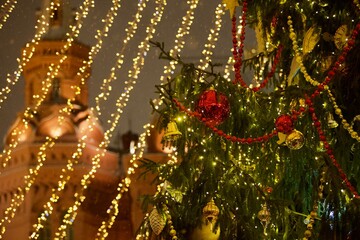 Christmas fair decorated with beautiful colorful Christmas decorations, bright toys, sparkling garlands and balls. Festive Christmas lights and magical decorations at the Christmas market at night.