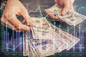 Multi exposure of financial graph drawing hologram and USA dollars bills and man hands. Analysis concept.
