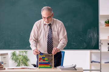 Old male teacher in the classroom
