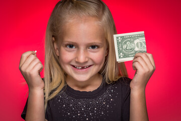 Little Girl Holding Tooth and Dollar Bill Smiling With Missing Tooth