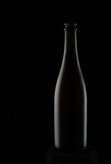 Black bottle on Black bottle on a black background with highlights. Two highlights show the volume of the bottle. To advertise drinks.a black background with highlights. High quality photo