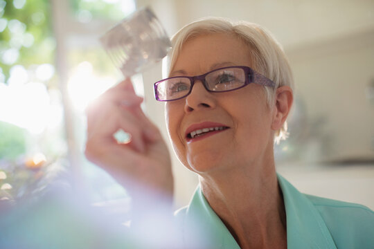 Curious senior woman examining cube in sunlight