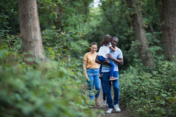Family hiking on trail in woods