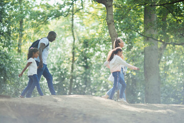 Family hiking in sunny summer woods
