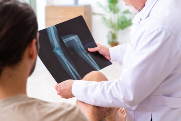 Experienced doctor radiologist examining young male patient