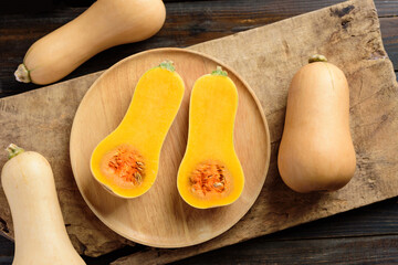 Half butternut squash on wooden plate for cooking, Top view