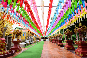 Fototapeta na wymiar Colorful paper lanterns Lanna style hanging for worship or respect of buddha in Wat Phra That Hariphunchai, northern of Thailand