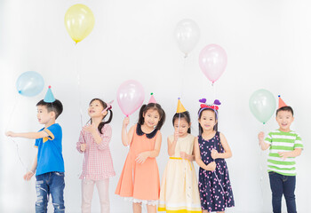 lpretty asian children group standing and celebrate, they feeling happy in birthday party, they...