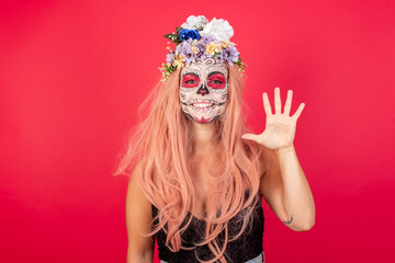 young beautiful woman wearing halloween make up over red background showing and pointing up with fingers number five while smiling confident and happy.