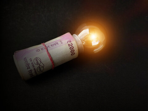 Financial innovation idea, creative solutions depicted by glowing light bulb and money bank notes