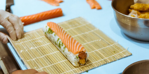 Closeup of chef hands preparing japanese food. Japanese chef making sushi at restaurant.