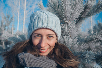 portrait of a beautiful girl in a hat on the background of the snow landscape in the cold season. winter walking. snowy weather