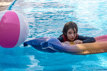 niña pequeña jugando en la piscina