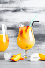 Glass of fresh peach lemonade on table