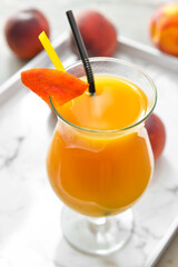 Glass of fresh peach juice on table