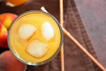 Glass of fresh peach juice on table