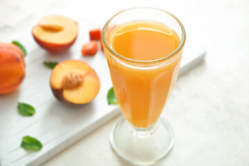 Glass of fresh peach juice on table