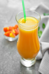 Glass of fresh peach juice on table