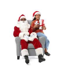 African-American Santa Claus with cute little girl on white background