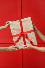 Hands with gift box on color background