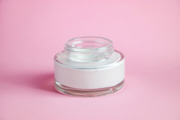 Bottle with cosmetic cleanser on pink background. Skin care concept.