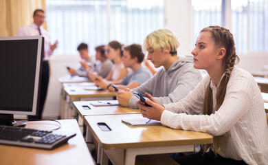 Obraz premium Portrait of teen pupils using mobile phones during lesson