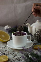 lavender tea in a white mug. Purple tea in a mug on a light background stands on the table next to lavender flowers