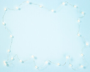 Christmas frame from luminous Christmas or New Year garland on blue background
