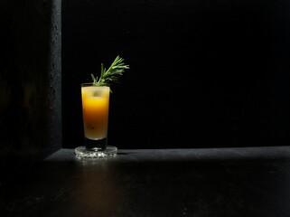 Rosemary greyhound vodka cocktail isolated against a black background