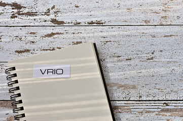 There is a card on the table with "VRIO (Value, Rarity, Imitability, Organization)" written on it, on a notebook.